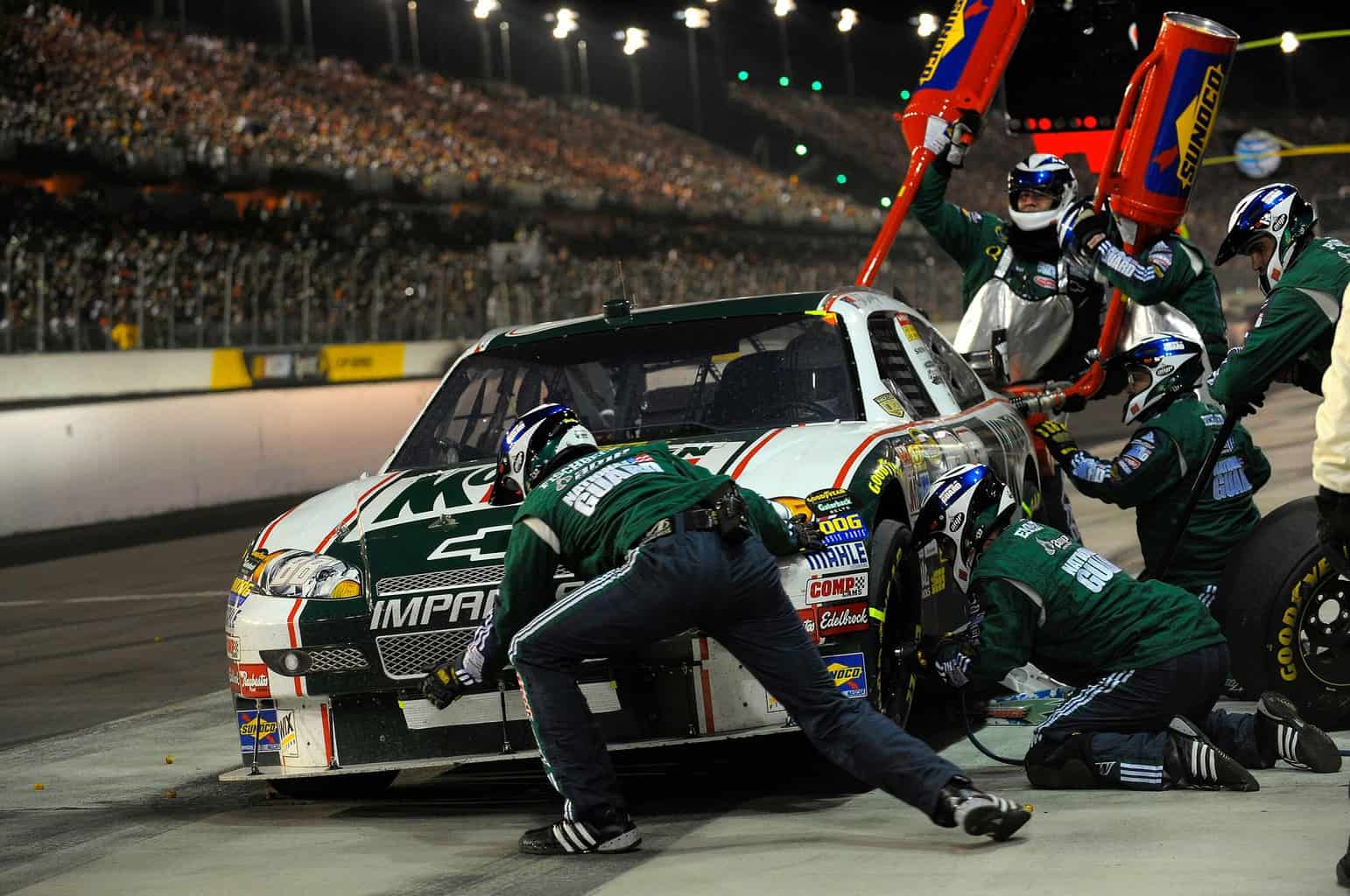 Nascar pitstop mechanic is seen using an impact wrench