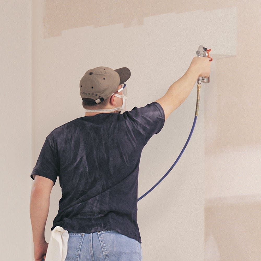 Picture of a man spray painting a wall